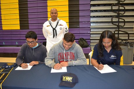 Left to right: Victor Gonzalez, Noah Gonzalez and Jasmine Barrera sign their agreements to enter the armed services. All three have signed up for the U.S. Navy.